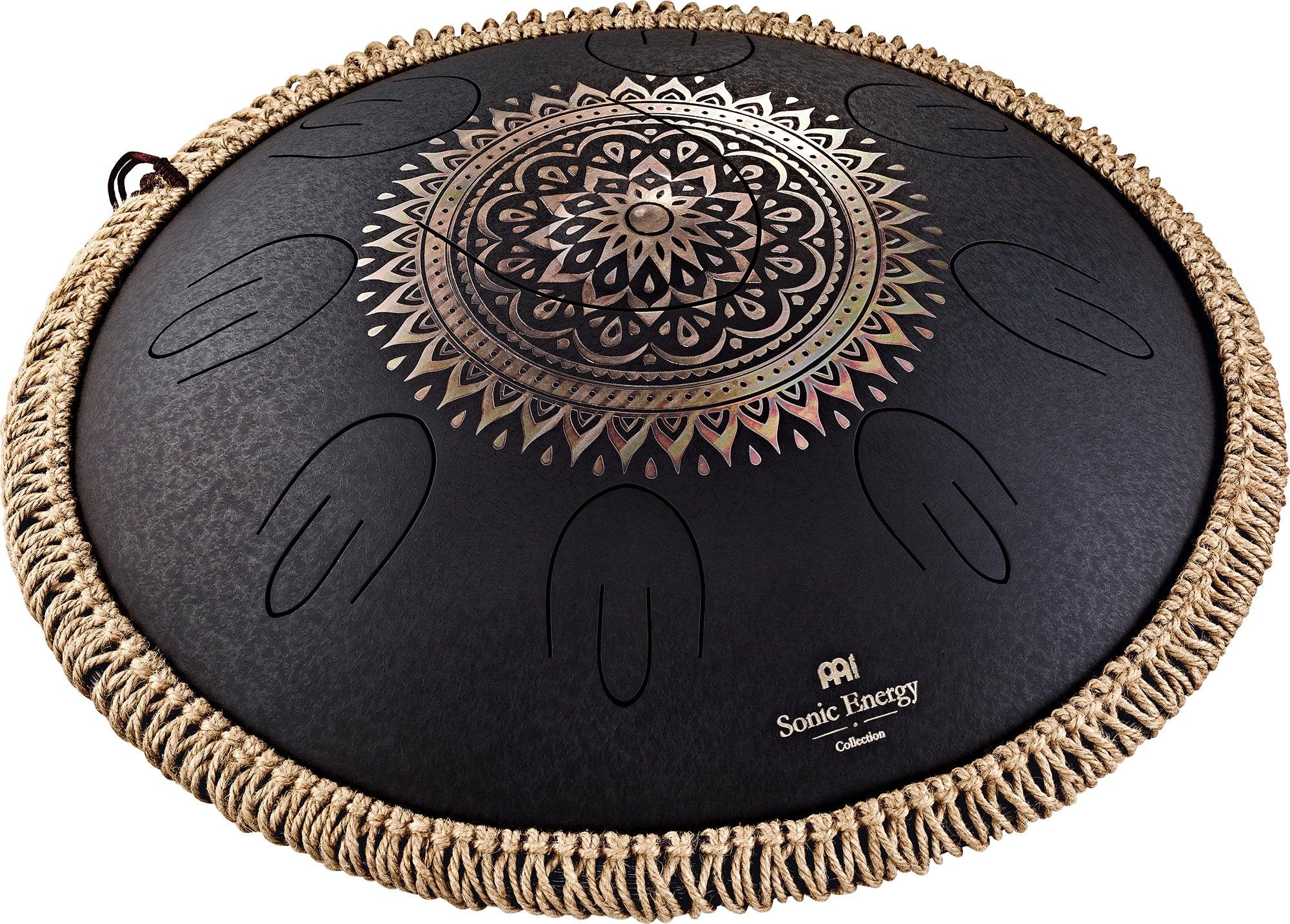 Black steel tongue drum with engraved mandala design and woven rope edge, used for sound healing