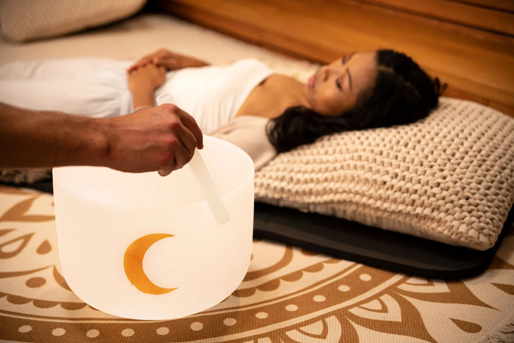 Crystal singing bowl with gold crescent moon used during sound healing session