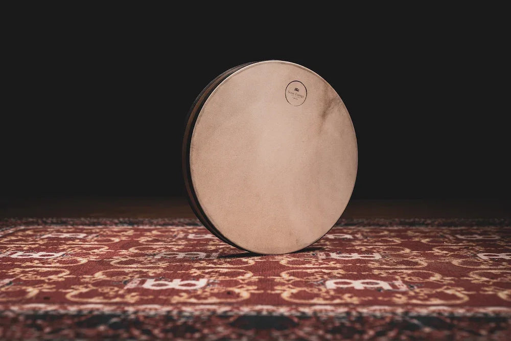 Frame drum with natural skin head on patterned rug, percussion instrument for sound healing
