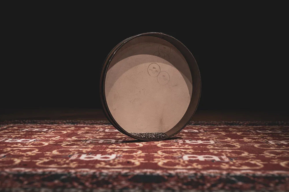 Frame drum for sound healing on patterned rug with dark background