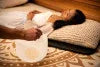 Woman relaxing on floor pillows during sound healing session with quartz singing bowl