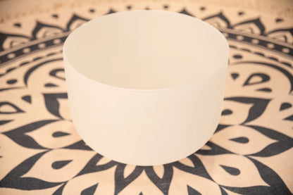 White crystal singing bowl on patterned mat for sound healing and meditation