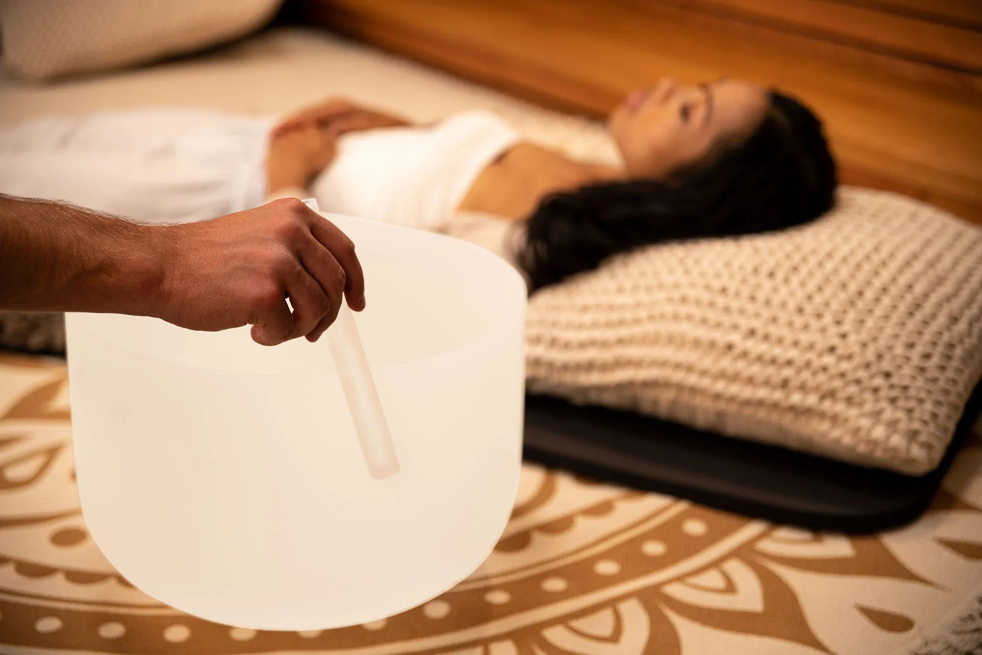Crystal singing bowl sound healing session with person lying on relaxation mat