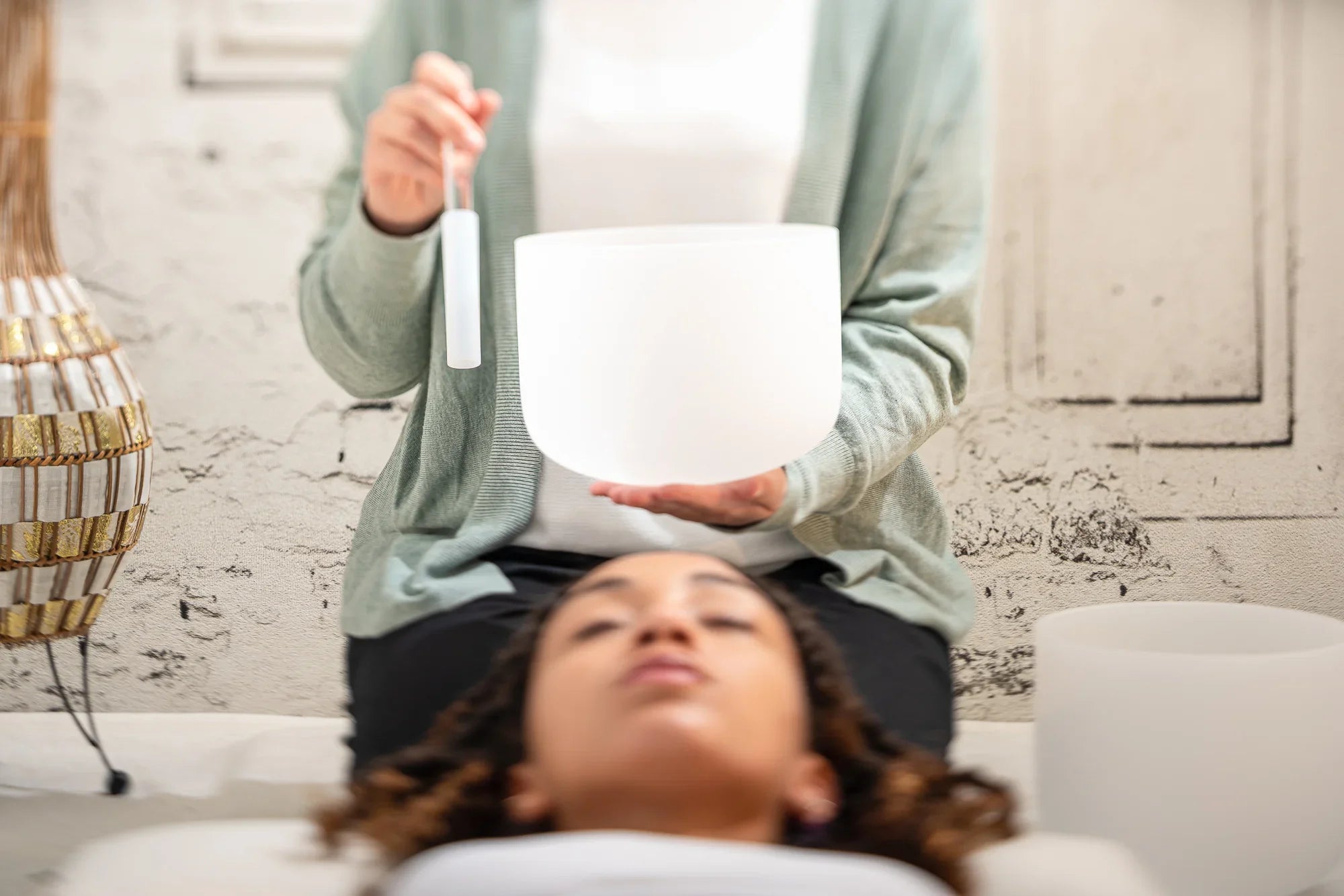 Crystal singing bowl sound healing session with practitioner and relaxed client