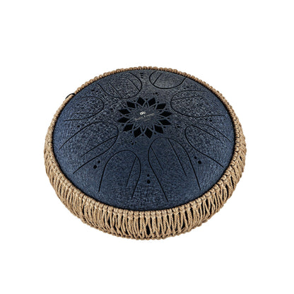 Black steel tongue drum with decorative cutouts and woven natural fiber trim, isolated on white background.