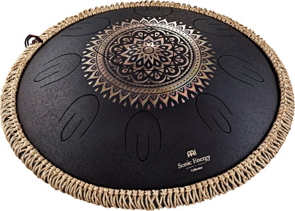 Black steel tongue drum with engraved mandala design and woven rope edge, used for sound healing