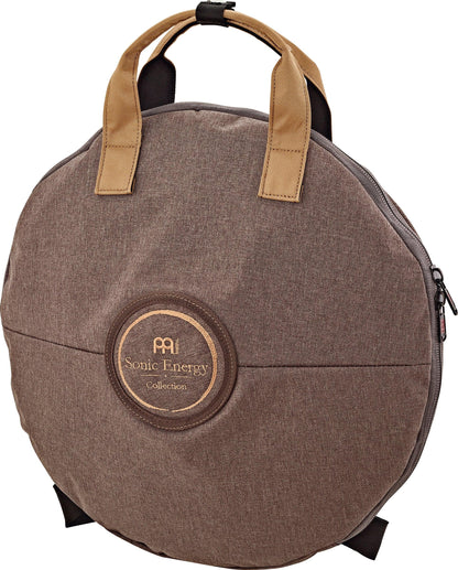 Round brown carrying case for sound healing instruments with tan handles and stitched logo patch