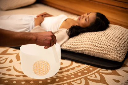 Sound healing session with crystal singing bowl and relaxed woman on cushion