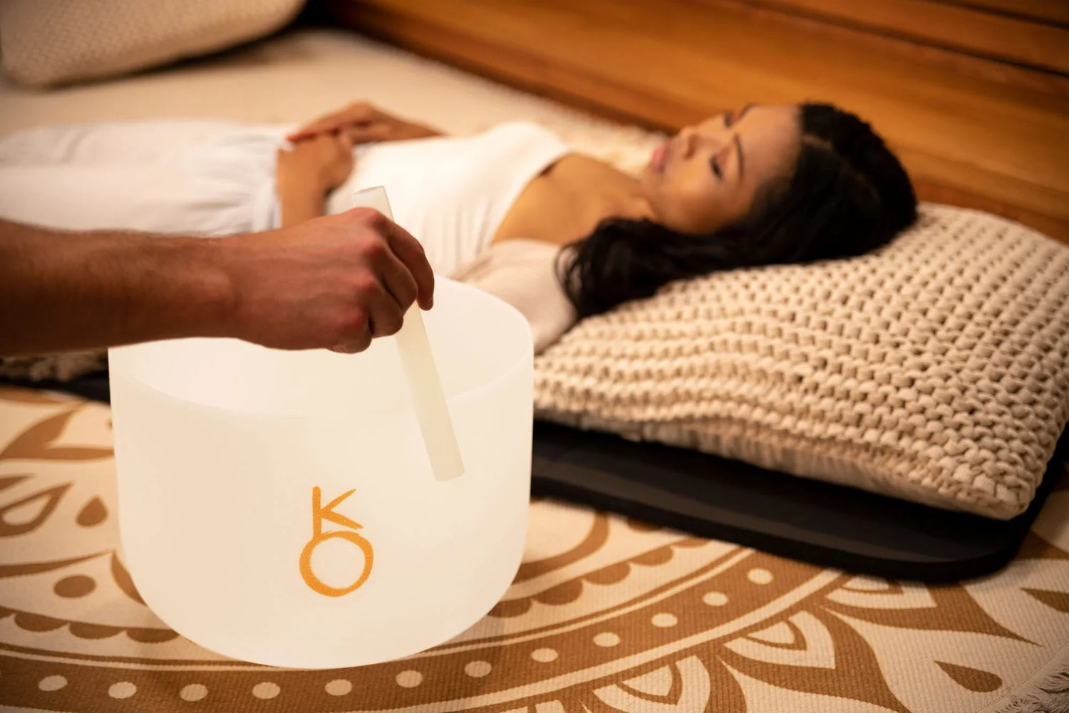 Sound healing session with crystal singing bowl and woman relaxing on mat
