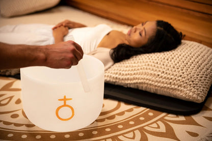 Sound healing session with crystal singing bowl and relaxed woman resting on pillow