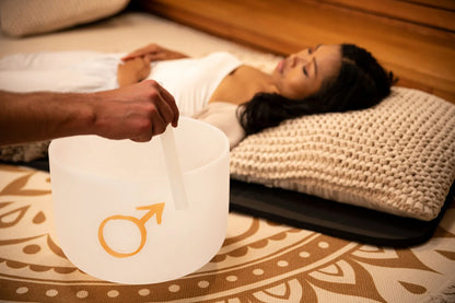 Crystal singing bowl sound healing session with woman relaxing on yoga mat