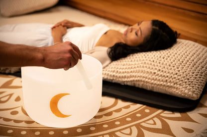 Crystal singing bowl with gold crescent moon used during sound healing session