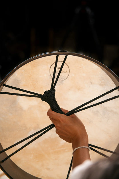 Close-up of hand holding a large frame drum for sound healing and meditation