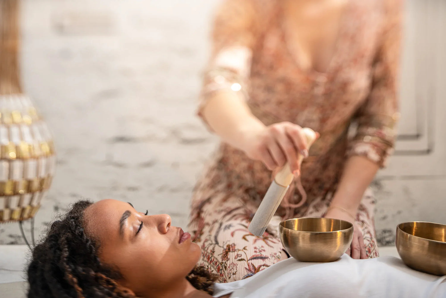 Sound healing session with singing bowls placed on a person lying down