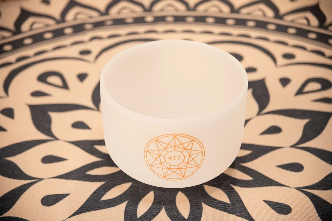 Frosted crystal singing bowl with 417 Hz symbol on mandala-patterned mat