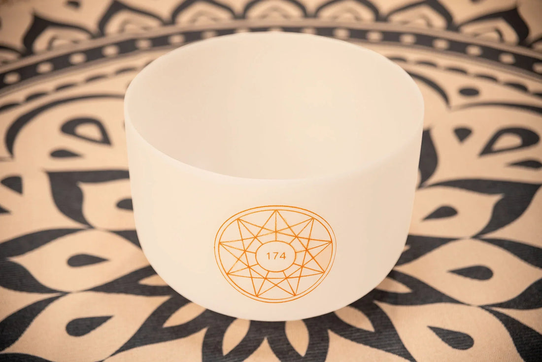 White crystal singing bowl with geometric 174 Hz design on mandala-patterned mat