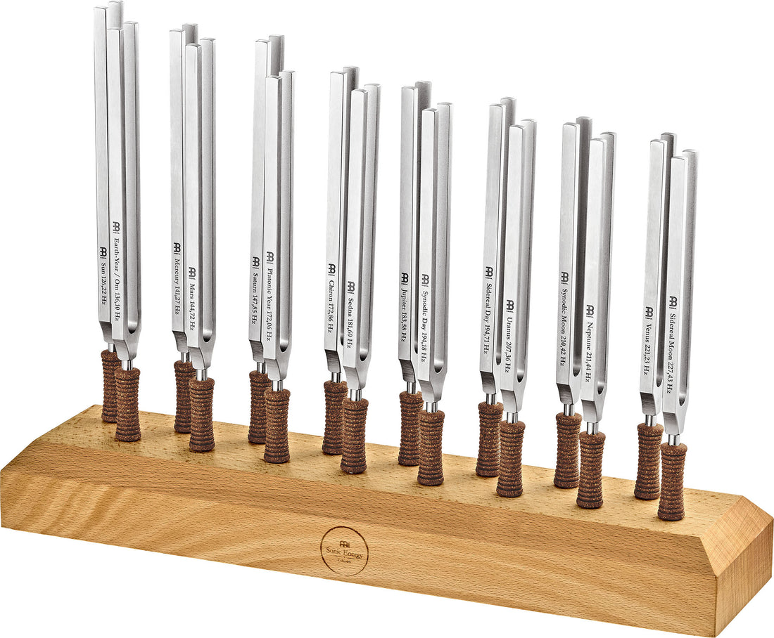 Set of eleven metal tuning forks with brown handles in a wooden stand for sound healing